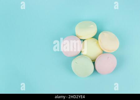 Close-Up Of Multi Colored Marshmallows looks like macaroons In Plate On Blue Background. Marshmallow concept Stock Photo