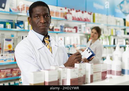 Man pharmacist making notes on clipboard during inventory Stock Photo