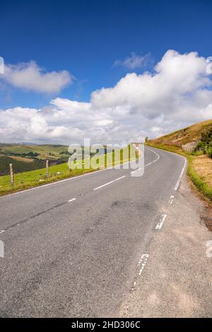 Road through sunlit countryside, Ceredigion, Wales Stock Photo