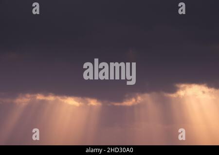Close up view of dramatic susnet sky with sunrays breaking throught the clouds. Stock Photo