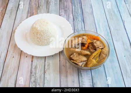 Sancocho is a stew made with tubers, vegetables, condiments, meats and a plate of white rice. Stock Photo