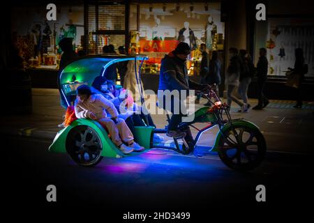 Rickshaw tricycle taxi In London with Passengers Stock Photo