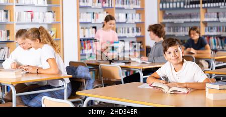 Group of girls and boys preparing for exams in library Stock Photo