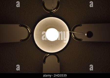 Low angle shot of a ceiling fan with the light turned on in a hotel room Stock Photo