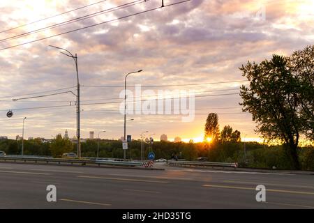 summer, heat, travel, weather, cityscape - background wide paved roadway road with city cars in spring hot evening at sunset, summertime sunrise grey Stock Photo
