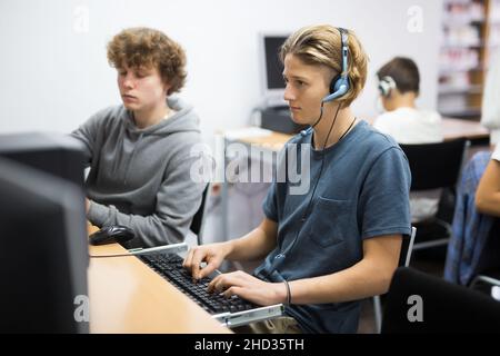 Schoolboy and schoolgirl working with computers in class room Stock Photo