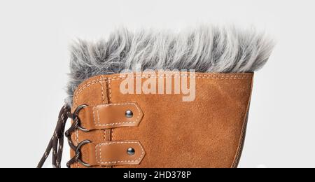 Partial winter boot top with fur and lace, lace ring and stitching, close up. Side view of brown or light brown pac boots or snow boots with water res Stock Photo