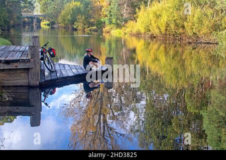 Cyclist by the Ovens River in Porepunkah along the Murray to Mountains Rail Trail Stock Photo