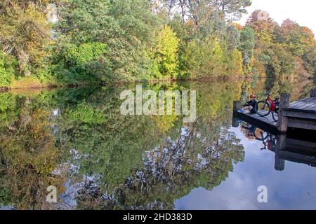 Cyclist by the Ovens River in Porepunkah along the Murray to Mountains Rail Trail Stock Photo