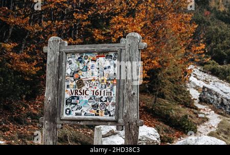 Wooden road sign full of stickers on top of Vrsic mountain pass in the Julian Alps in Slovenia Stock Photo