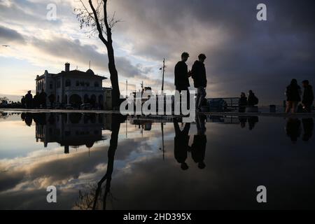 Istanbul, Turkey. 02nd Jan, 2022. Silhouettes of people reflected in the puddle of water after rainfall. Credit: SOPA Images Limited/Alamy Live News Stock Photo