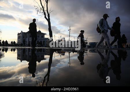 Istanbul, Turkey. 02nd Jan, 2022. Silhouettes of people reflected in the puddle of water after rainfall. Credit: SOPA Images Limited/Alamy Live News Stock Photo