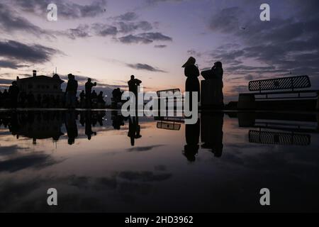 Istanbul, Turkey. 02nd Jan, 2022. Silhouettes of people reflected in the puddle of water after rainfall. Credit: SOPA Images Limited/Alamy Live News Stock Photo