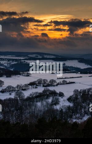 Vertical view of a sunset over a snow-covered rural area in Nideggen, Eifel, Germany in winter Stock Photo