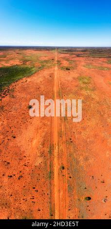 Endless plains of Australian outback semi desert around Broken hill in vertical aerial panorama along dirt track. Stock Photo
