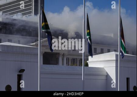 South Africa's national parliament smouldering after a fire broke out in the early hours of 2 January 2022 in Cape Town Stock Photo