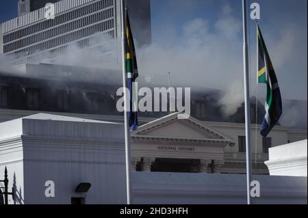 South Africa's national parliament smouldering after a fire broke out in the early hours of 2 January 2022 in central Cape Town Stock Photo