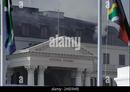 South Africa's national parliament smouldering after a fire broke out in the early hours of 2 January 2022 in central Cape Town Stock Photo