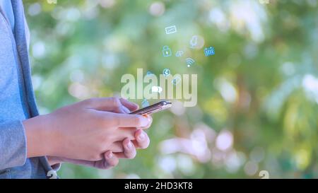 The boy wearing glasses using smart phone with Social media with icons,  living on vacation and playing social media concept Businessman using phone , Stock Photo