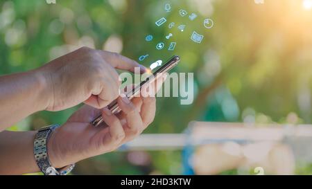 The boy wearing glasses using smart phone with Social media with icons,  living on vacation and playing social media concept Businessman using phone , Stock Photo
