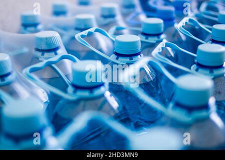 Many blue plastic bottles with blue caps with mineral water in a supermarket. Close Up. Main subject of a focus Stock Photo
