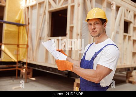 Handsome man studying architectural plan at construction site Stock Photo