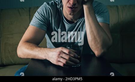 unrecognizable man drinks whiskey from glass Stock Photo