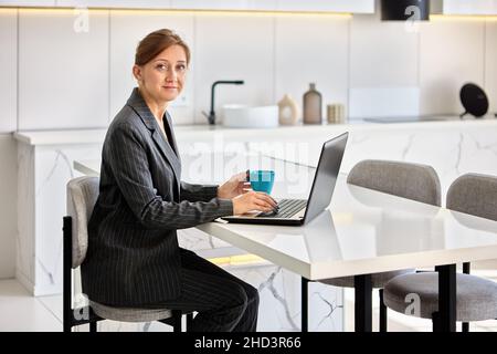 Live streaming virtual classes by businesswoman with laptop indoors. Stock Photo