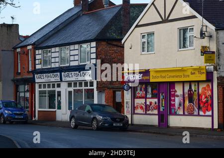 Prestatyn, UK: Dec 14, 2021: Karl's fish and chips shop and a Premier Express convenience store on Station Road. Stock Photo