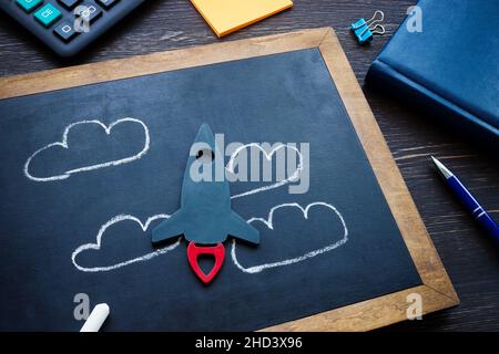 Small rocket and drawn clouds as symbol of dreams and new ideas in business. Stock Photo
