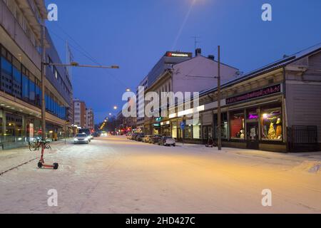 Turku, Finland - December 24, 2021: Horizontal Night Street View of Eerikinkatu Street with Parked Scooter and Taxi Stop in Forground, Pohjantahti Ins Stock Photo