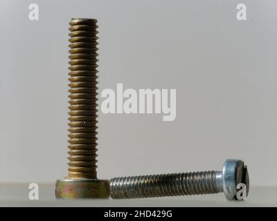 Close-up picture of a rusty gold and silver screw on a white background Stock Photo