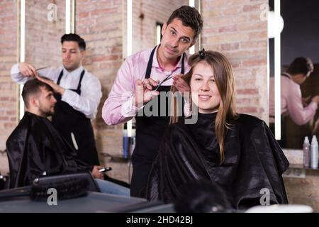 Brunette getting haircutting in salon Stock Photo