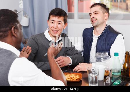 Happy males enjoying сonversation at table Stock Photo