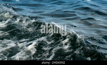Water Splash from Wake of a Boat. White foam and Bubbles on Crest of Wave in the Ocean. Clear Blue Waters with Waves Stock Photo