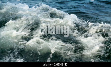 Water Splash from Wake of a Boat. White foam and Bubbles on Crest of Wave in the Ocean. Clear Blue Waters with Waves Stock Photo