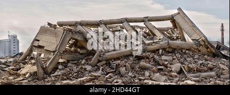 Collapsed and destroyed concrete industrial building isolated on white background. Disaster scene full of debris, dust and damaged house Stock Photo