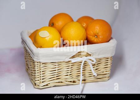 Mock up label on oranges. Wicker basket with oranges and product sticker on it for text or price. Organic farm products from local market Stock Photo