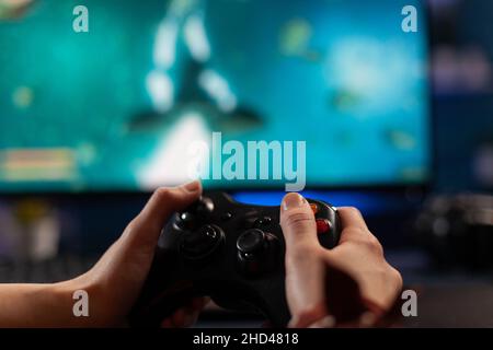 Gamer using controller to play online video games on computer. Man playing  game with joystick and headphones in front of monitor. Player having gaming  equipment, doing fun activity Stock Photo - Alamy