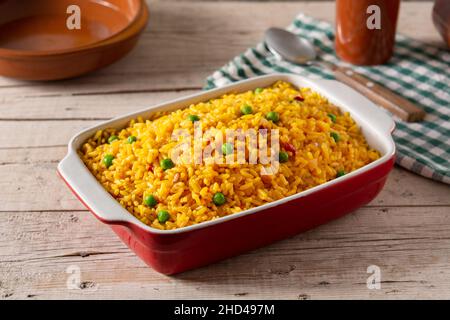 Traditional Mexican rice served with green peas on wooden table Stock Photo