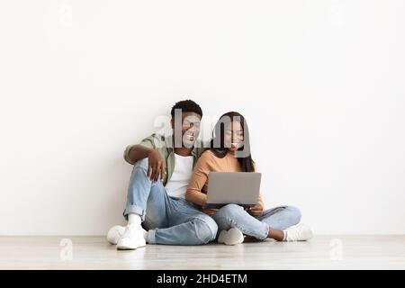 Happy black man and woman using notebook together Stock Photo
