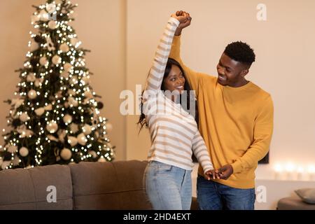 Black Couple Dancing Near Christmas Tree Celebrating New Year Indoor