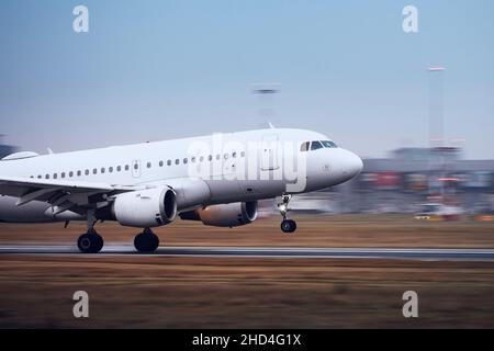 Airplane during landing on airport runway at night. Plane in blurred motion. Stock Photo