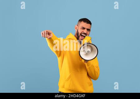 It is your chance. Middle eastern guy with megaphone making announcement, saying something loud and pointing at camera Stock Photo