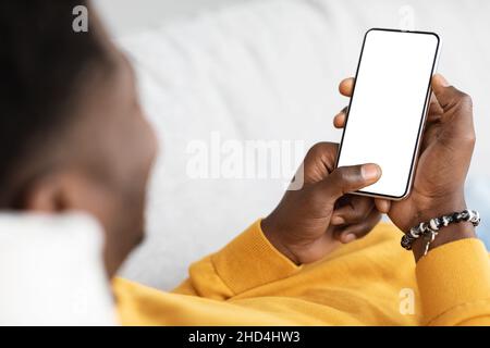 Unrecognizable black guy using mobile phone with empty screen Stock Photo