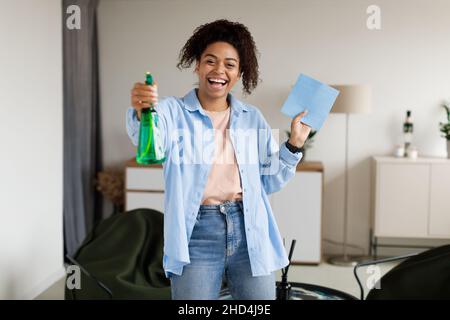 Portrait of black woman cleaning house singing holding rag Stock Photo