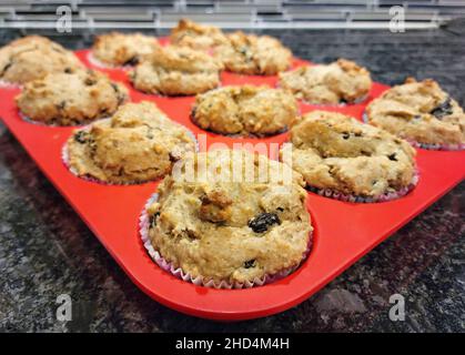 Close up of bran muffins with raisins in a red silicone baking pan Stock Photo