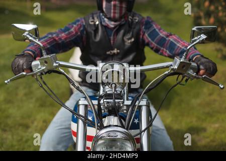 Selective focus shot of a driver riding a USA themed harley Davidson with a helmet on Stock Photo