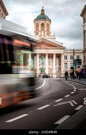 Vertical shot of long exposure of a bus driving against the Church of St. James in Brussels, Belgium Stock Photo