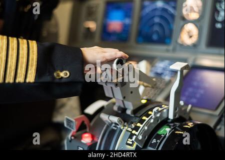 Female pilot's hand on the plane engine control stick. Stock Photo